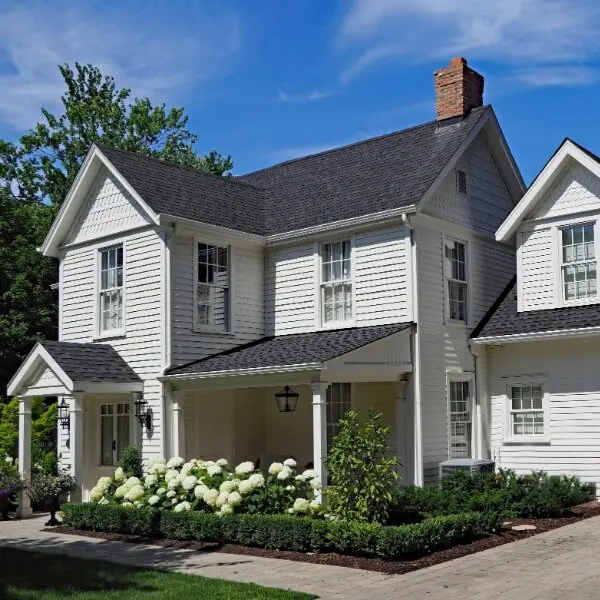 Charming two-story home featuring tan siding and brick accents, beautifully preserved with professional exterior painting in Addison MI.