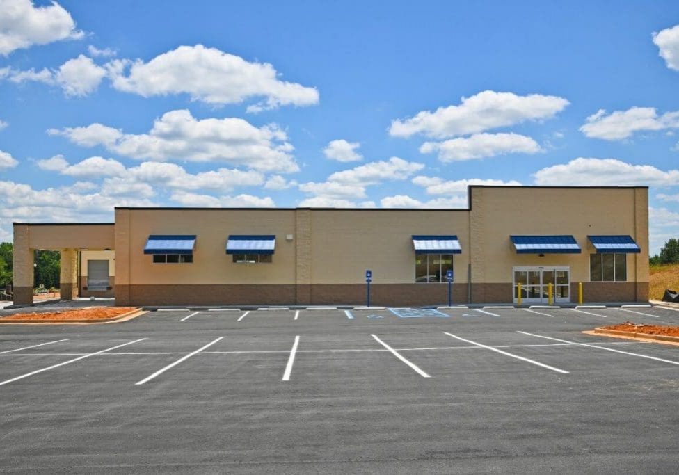 Freshly completed commercial exterior painting in Ann Arbor MI showcasing tan masonry and blue awnings on a modern retail building.